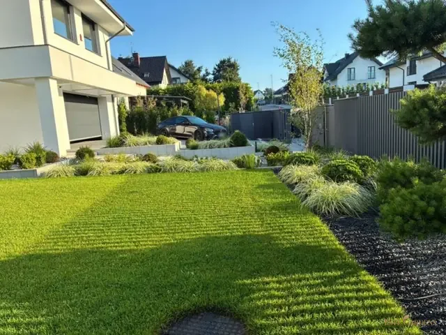 Trawnik przy nowoczesnym domu założony przez Este Gardens